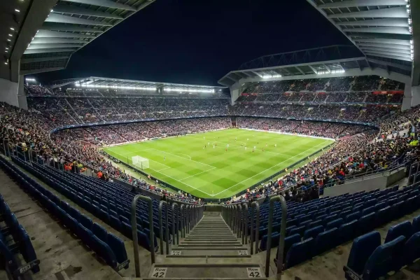 Campo de fútbol visto desde las gradas altas de un gran estadio europeo iluminado de noche